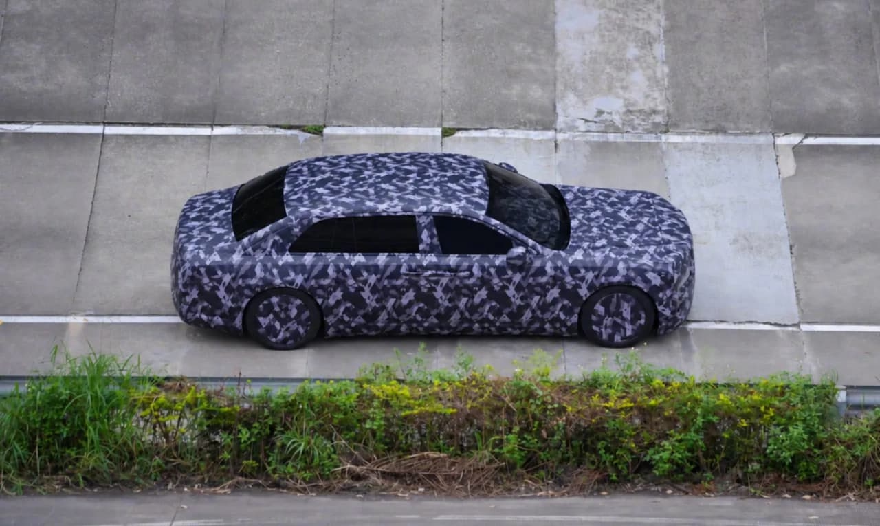 A camouflaged prototype of a long-wheelbase luxury sedan.