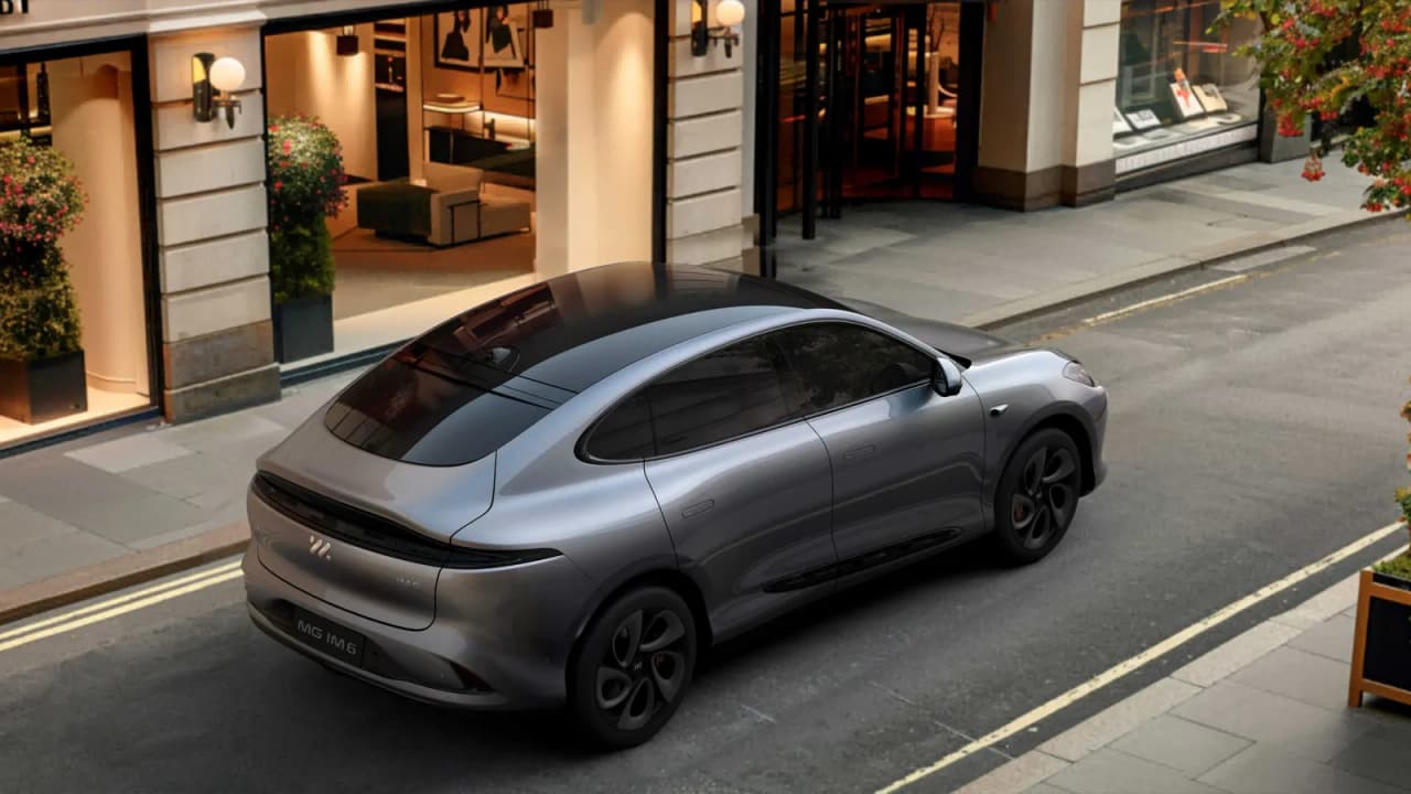 A gray MG IM6 electric SUV parked on a city street.