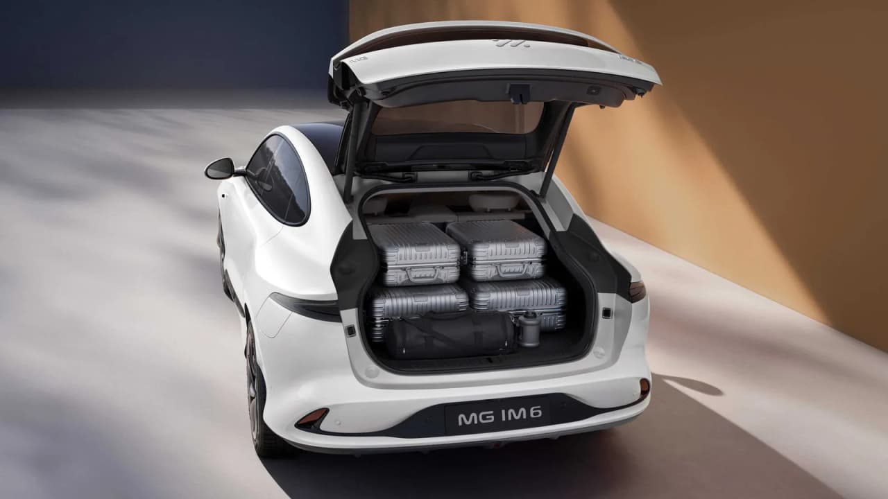 Rear view of the MG IM6 with the trunk open, showing luggage inside.